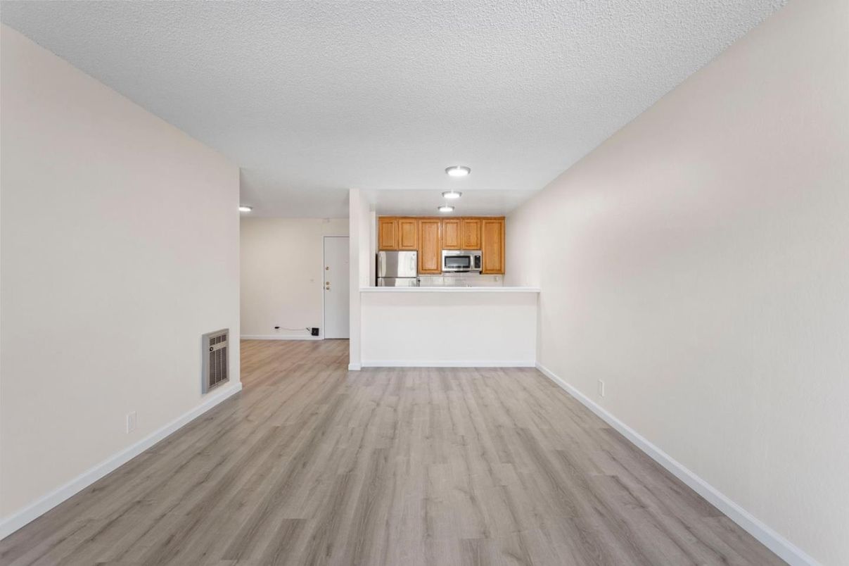 Empty room, Interior, Kitchen, Recessed Lighting, Stainless Steel Appliances, Wood Texture Flooring