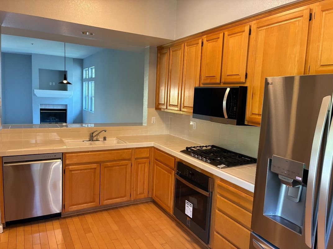 Fireplace, Interior, Kitchen, Pendant Lights, Stainless Steel Appliances, Tile Countertops, Wood Texture Flooring