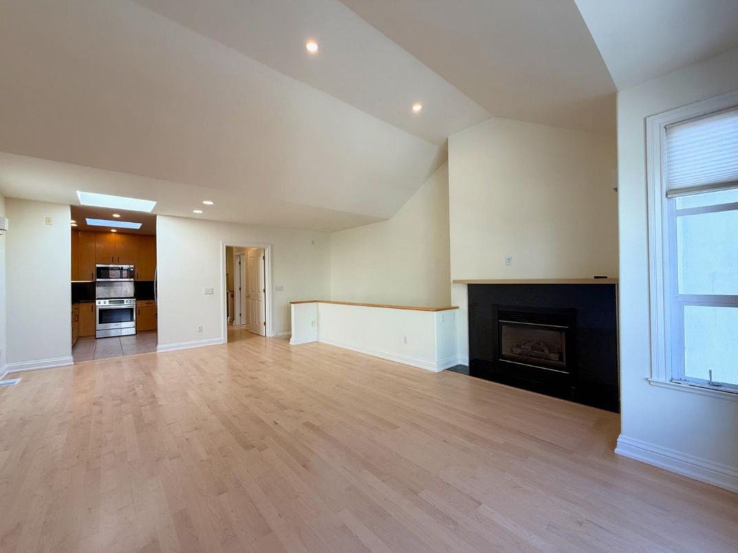 Empty room, Fireplace, Interior, Kitchen, Recessed Lighting, Stainless Steel Appliances, Wood Texture Flooring