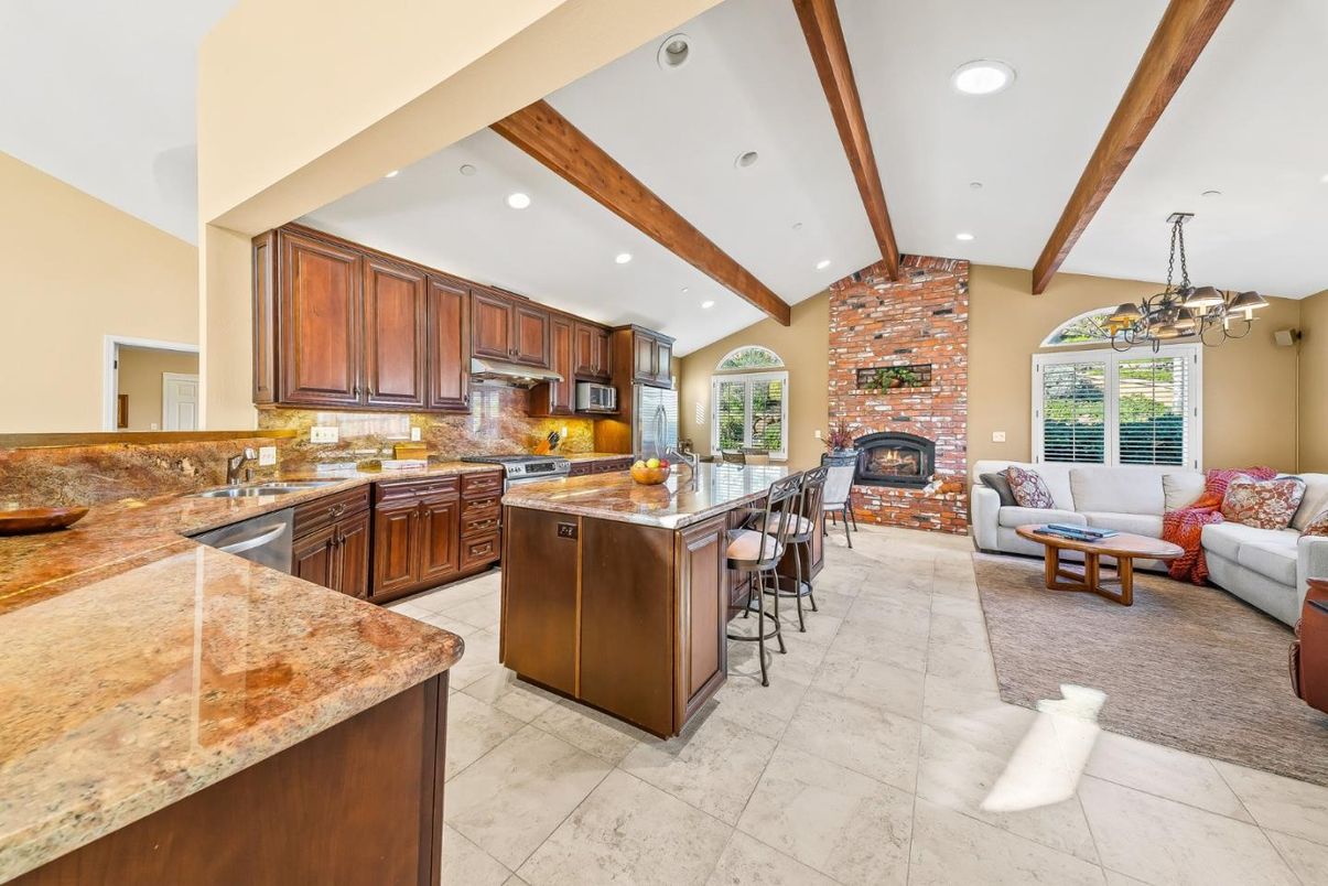 Chandelier, Fireplace, Interior, Kitchen, Living room, Pendant Lights, Recessed Lighting, Stainless Steel Appliances, Stone Walls, Wooden Beams