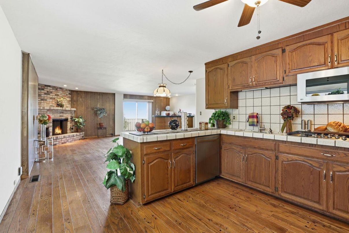 Fireplace, Interior, Kitchen, Pendant Lights, Recessed Lighting, Stone Walls, Tile Countertops, Wood Texture Flooring