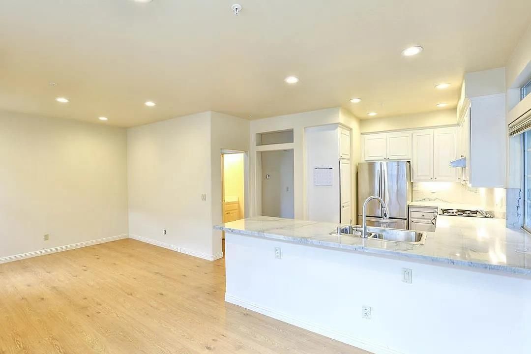 Empty room, Interior, Kitchen, Recessed Lighting, Stainless Steel Appliances, Wood Texture Flooring