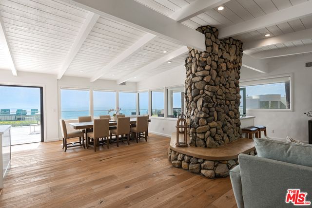 Dining room, Fireplace, Interior, Living room, Recessed Lighting, Stone Walls, Water, Wood Texture Flooring