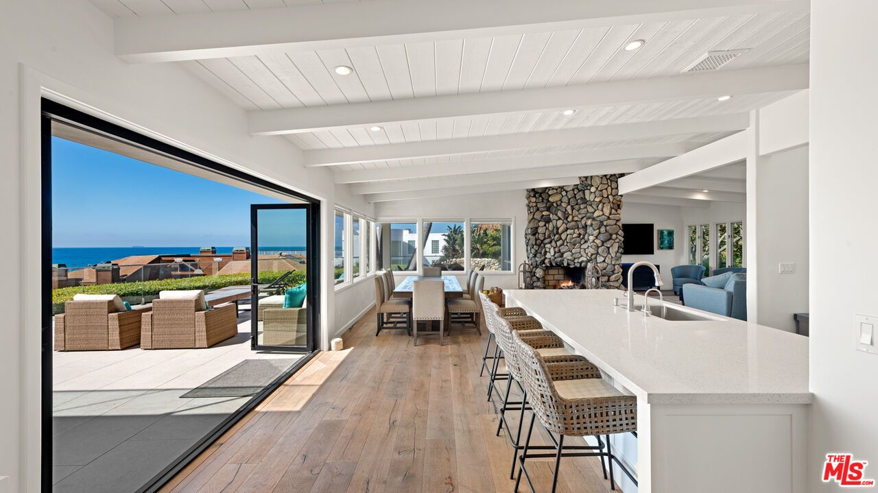 Dining room, Fireplace, Interior, Living room, Recessed Lighting, Stone Walls, Water, Wood Texture Flooring