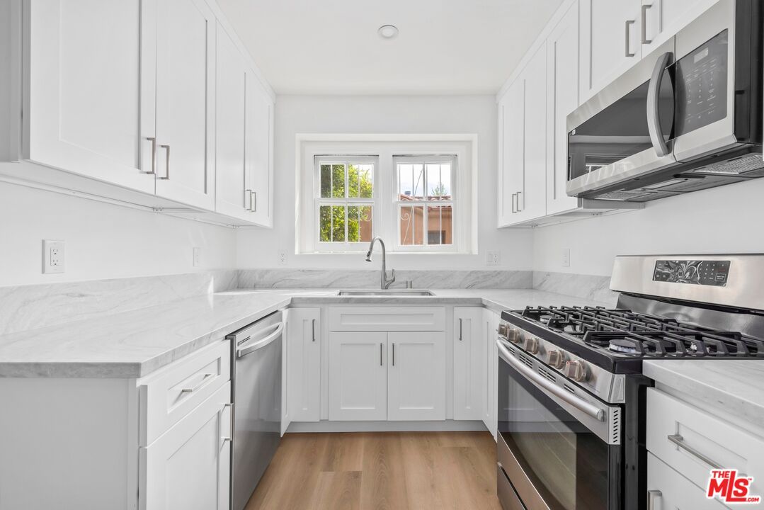 Interior, Kitchen, Marble Walls, Recessed Lighting, Stainless Steel Appliances, Wood Texture Flooring