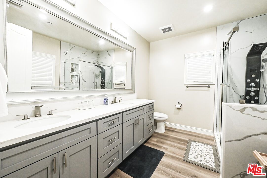 Bathroom, Dual Sink Vanities, Interior, Marble Walls, Recessed Lighting, Wood Texture Flooring