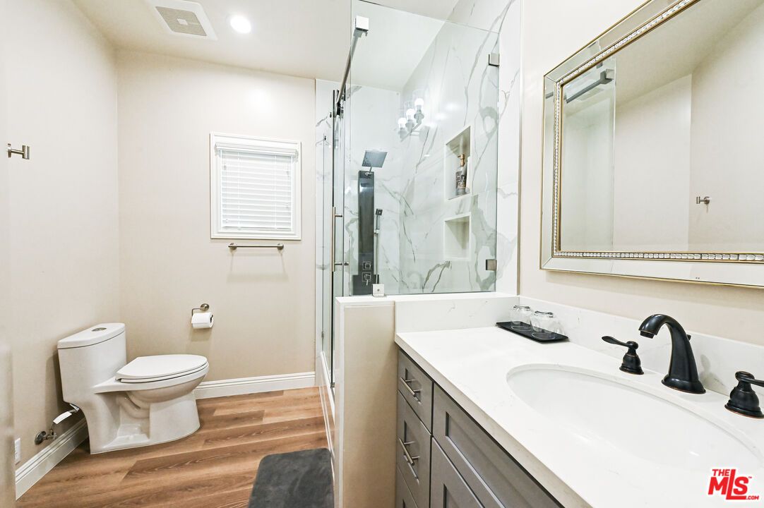 Bathroom, Dual Sink Vanities, Glass Shower, Interior, Marble Walls, Recessed Lighting, Wood Texture Flooring