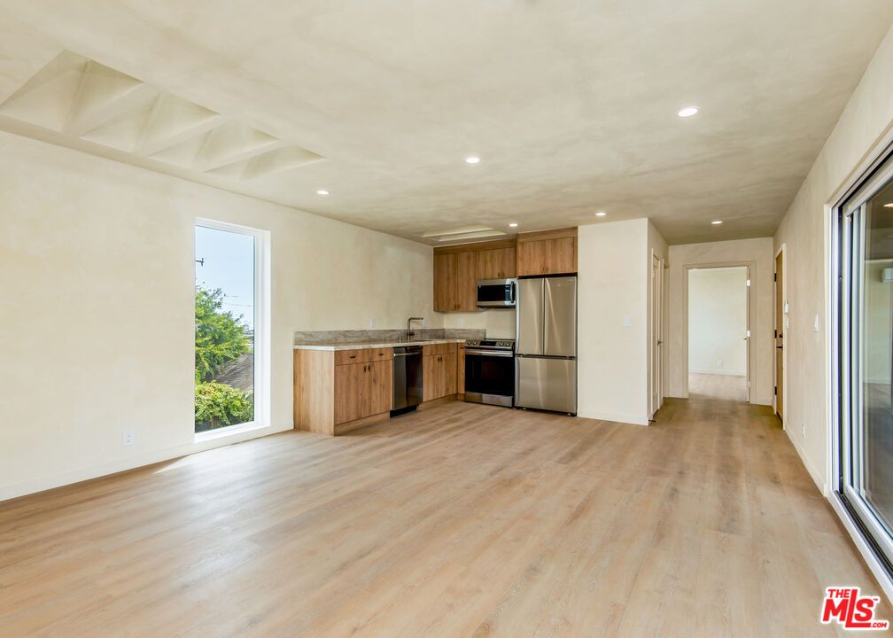 Empty room, Interior, Kitchen, Recessed Lighting, Stainless Steel Appliances, Wood Texture Flooring