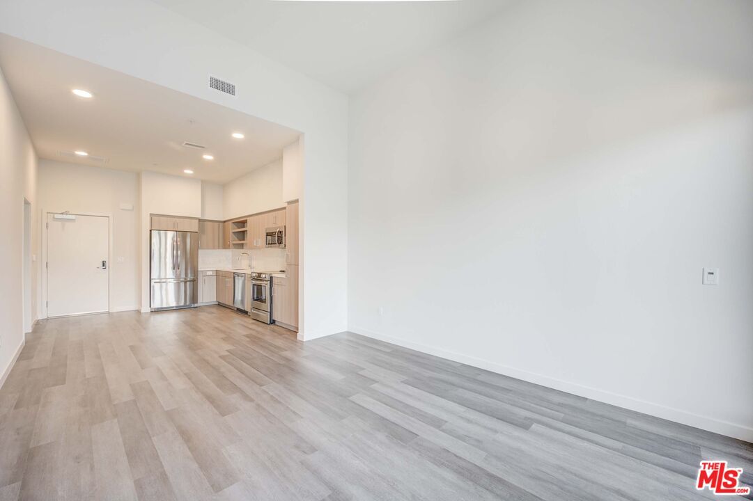 Empty room, Interior, Kitchen, Recessed Lighting, Stainless Steel Appliances, Wood Texture Flooring