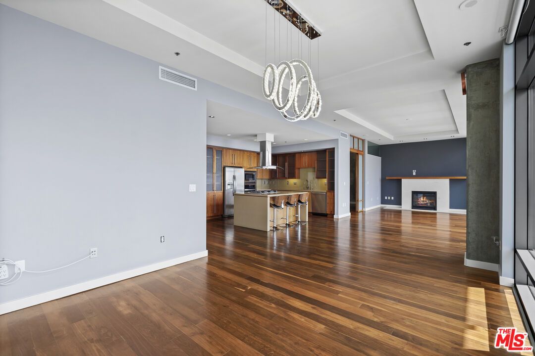 Empty room, Fireplace, Interior, Kitchen, Pendant Lights, Recessed Lighting, Stainless Steel Appliances, Wood Texture Flooring