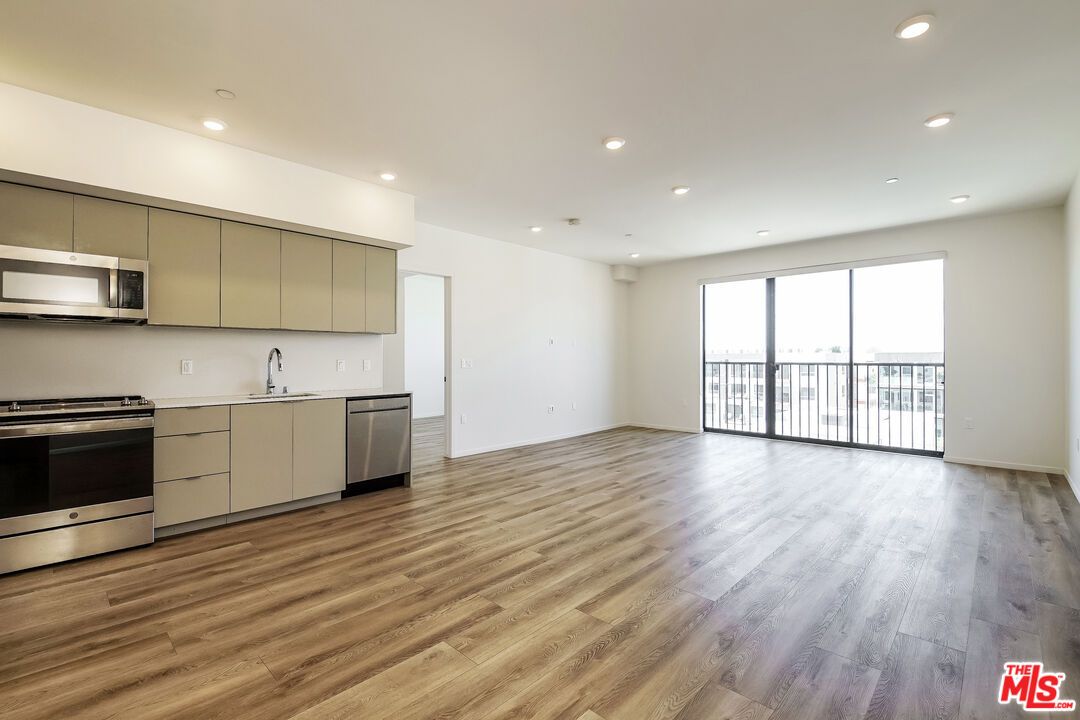 Empty room, Interior, Kitchen, Recessed Lighting, Stainless Steel Appliances, Wood Texture Flooring