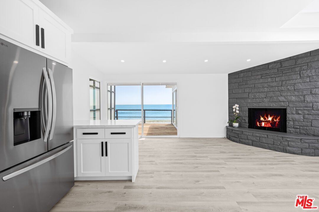 Fireplace, Interior, Kitchen, Recessed Lighting, Stainless Steel Appliances, Stone Walls, Water, Wood Texture Flooring