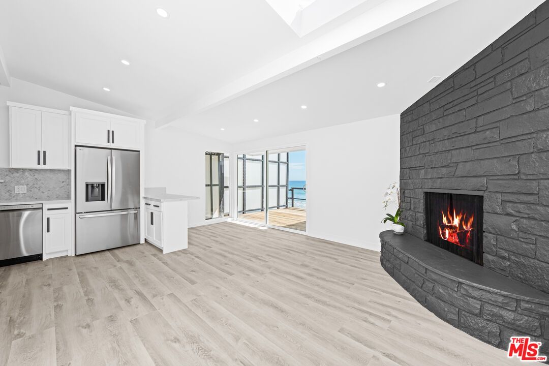 Fireplace, Interior, Kitchen, Living room, Recessed Lighting, Stainless Steel Appliances, Stone Walls, Water, Wood Texture Flooring