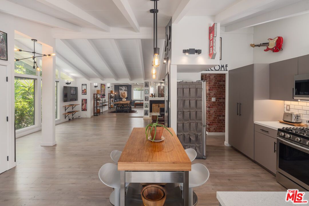 Dining room, Fireplace, Interior, Kitchen, Pendant Lights, Stainless Steel Appliances, Stone Walls, Wood Texture Flooring