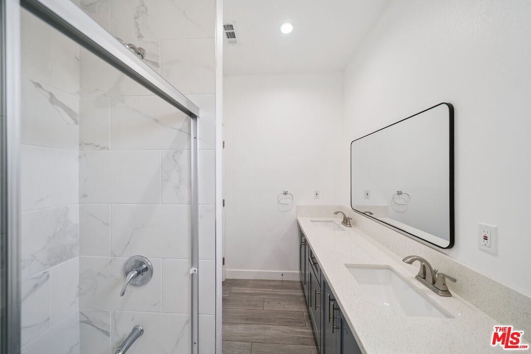 Bathroom, Dual Sink Vanities, Interior, Marble Walls, Recessed Lighting, Wood Texture Flooring