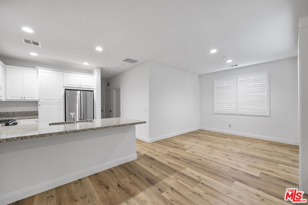 Empty room, Interior, Kitchen, Recessed Lighting, Stainless Steel Appliances, Wood Texture Flooring