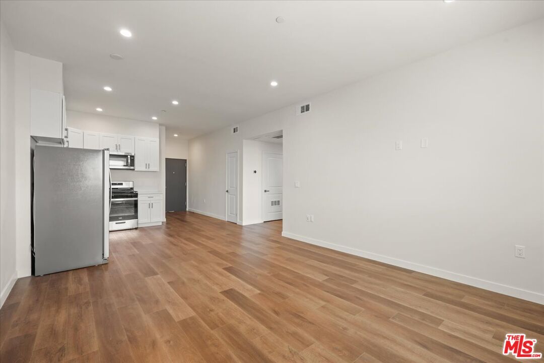 Empty room, Interior, Kitchen, Recessed Lighting, Stainless Steel Appliances, Wood Texture Flooring