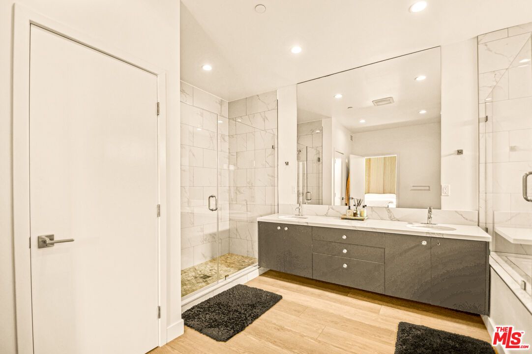 Bathroom, Dual Sink Vanities, Glass Shower, Interior, Marble Walls, Recessed Lighting, Wood Texture Flooring