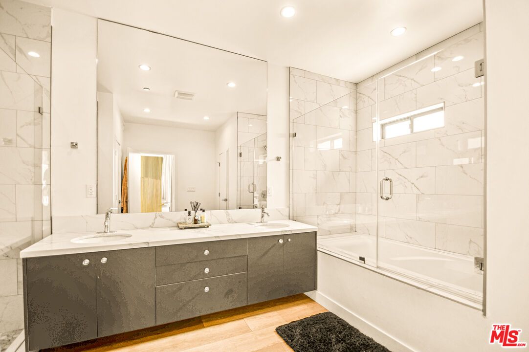 Bathroom, Dual Sink Vanities, Glass Shower, Interior, Marble Walls, Recessed Lighting, Wood Texture Flooring