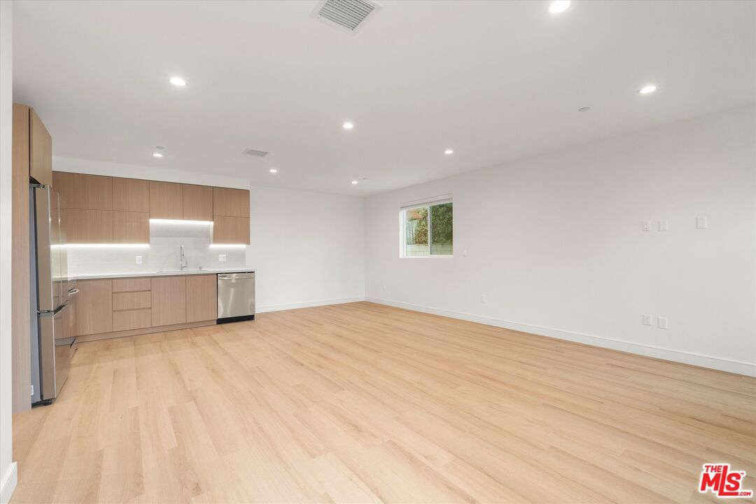 Empty room, Interior, Kitchen, Recessed Lighting, Stainless Steel Appliances, Wood Texture Flooring