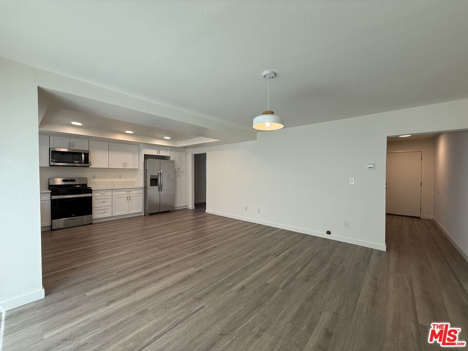 Empty room, Interior, Kitchen, Pendant Lights, Recessed Lighting, Stainless Steel Appliances, Wood Texture Flooring