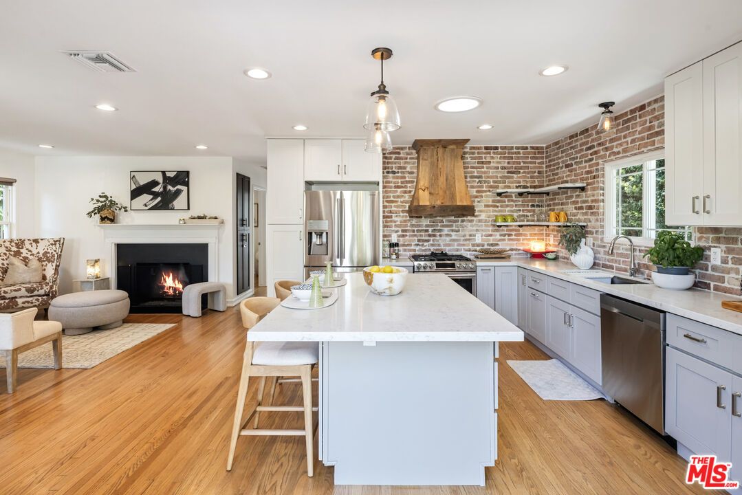 Fireplace, Interior, Kitchen, Living room, Pendant Lights, Recessed Lighting, Stainless Steel Appliances, Stone Walls, Wood Texture Flooring