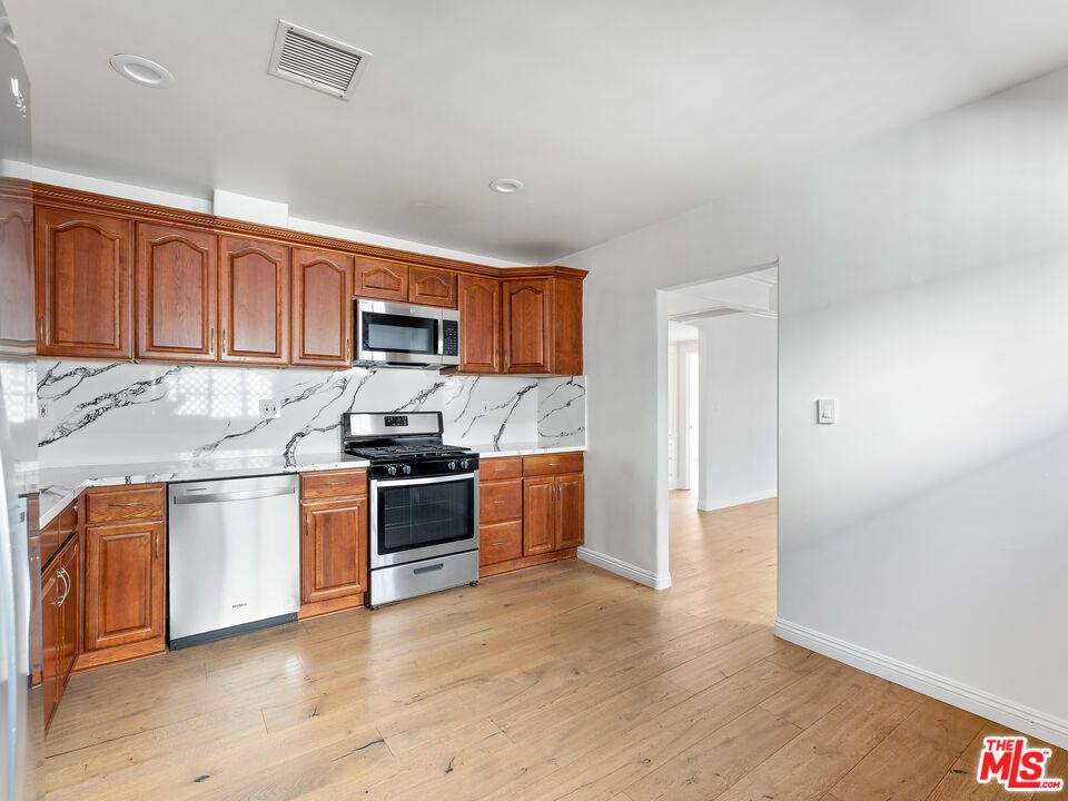 Interior, Kitchen, Marble Walls, Recessed Lighting, Stainless Steel Appliances, Wood Texture Flooring