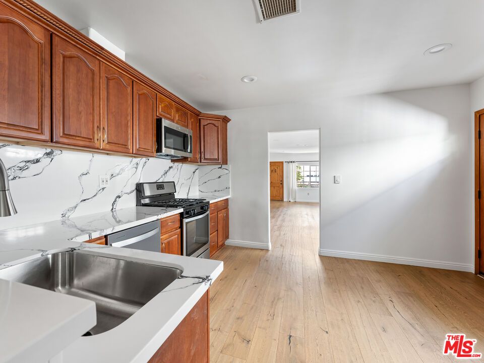 Interior, Kitchen, Marble Walls, Recessed Lighting, Stainless Steel Appliances, Wood Texture Flooring