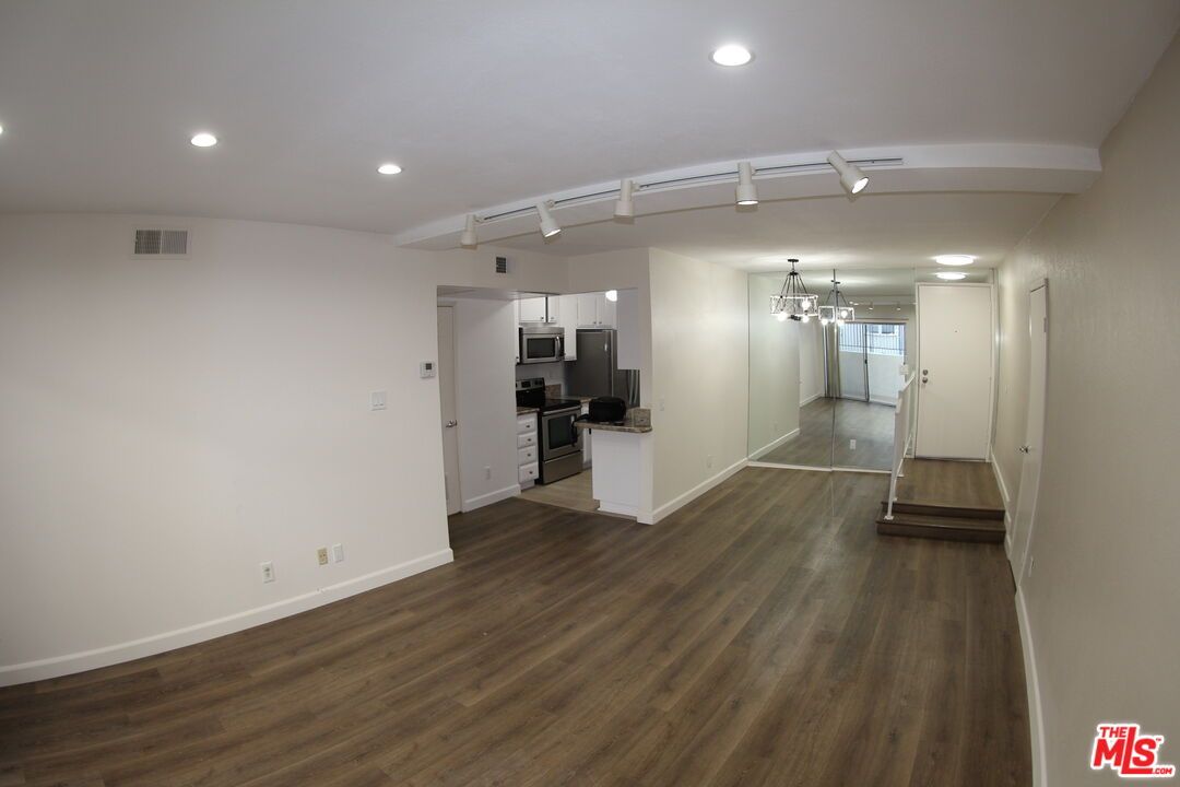 Empty room, Interior, Kitchen, Recessed Lighting, Stainless Steel Appliances, Wood Texture Flooring