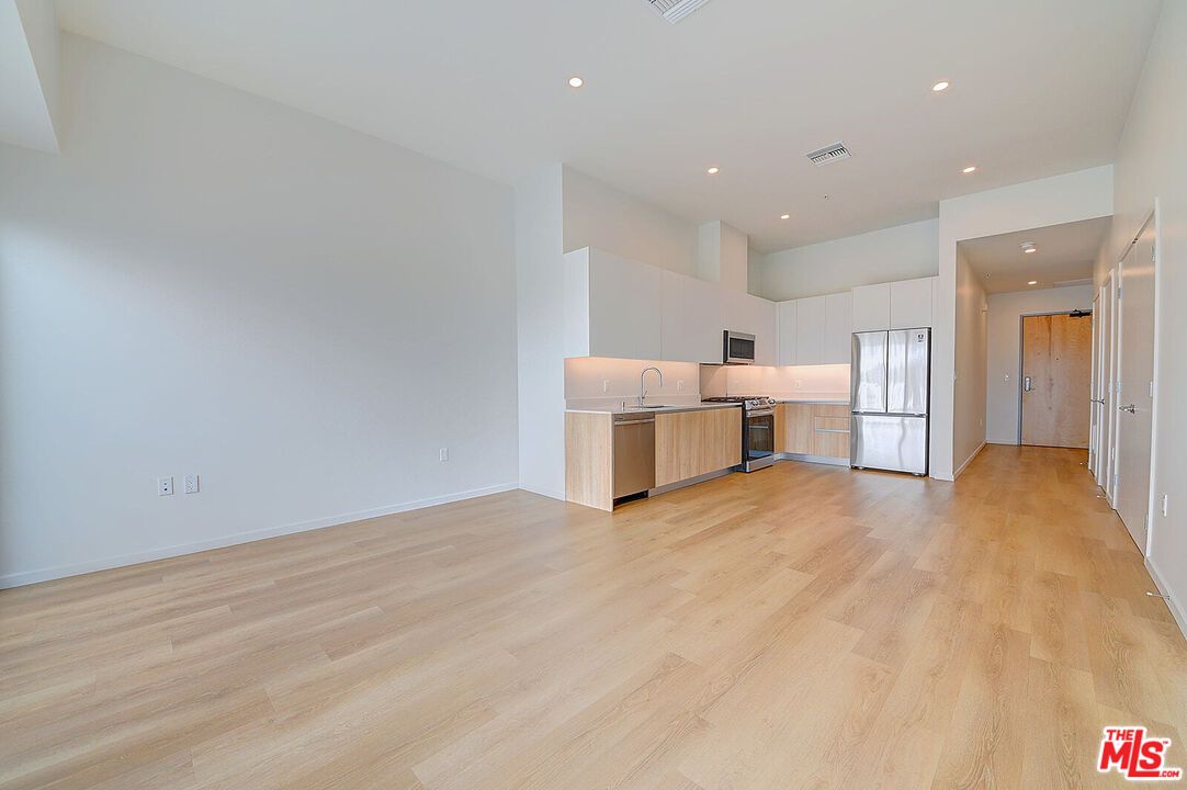 Empty room, Interior, Kitchen, Recessed Lighting, Stainless Steel Appliances, Wood Texture Flooring