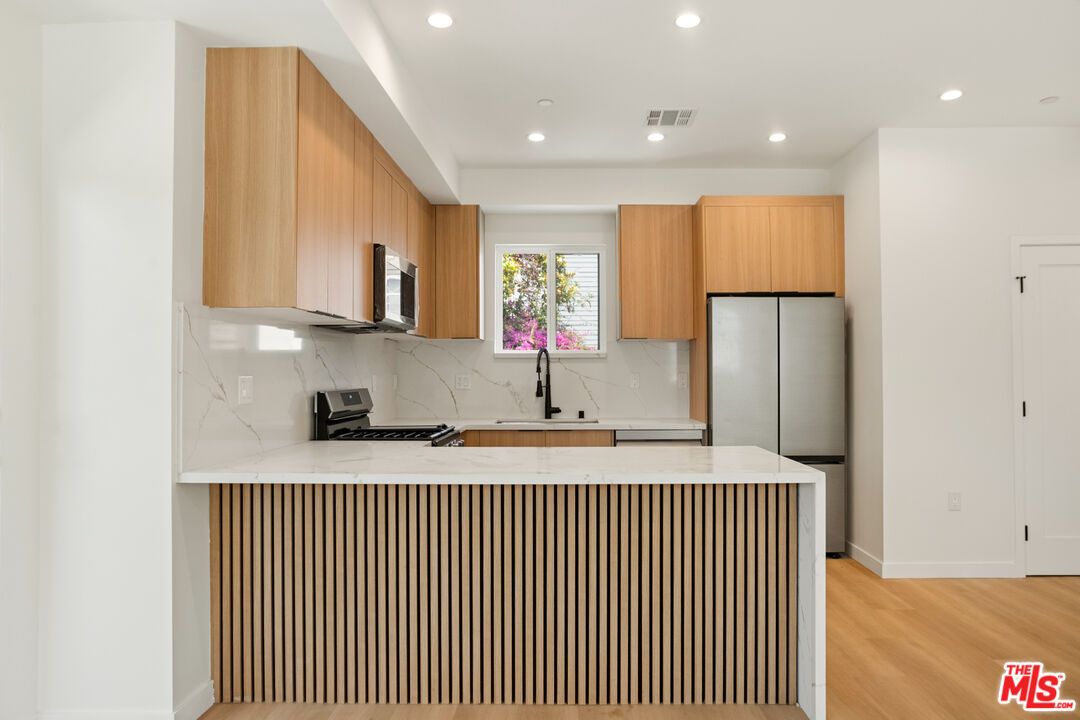 Interior, Kitchen, Marble Walls, Recessed Lighting, Stainless Steel Appliances, Wood Texture Flooring