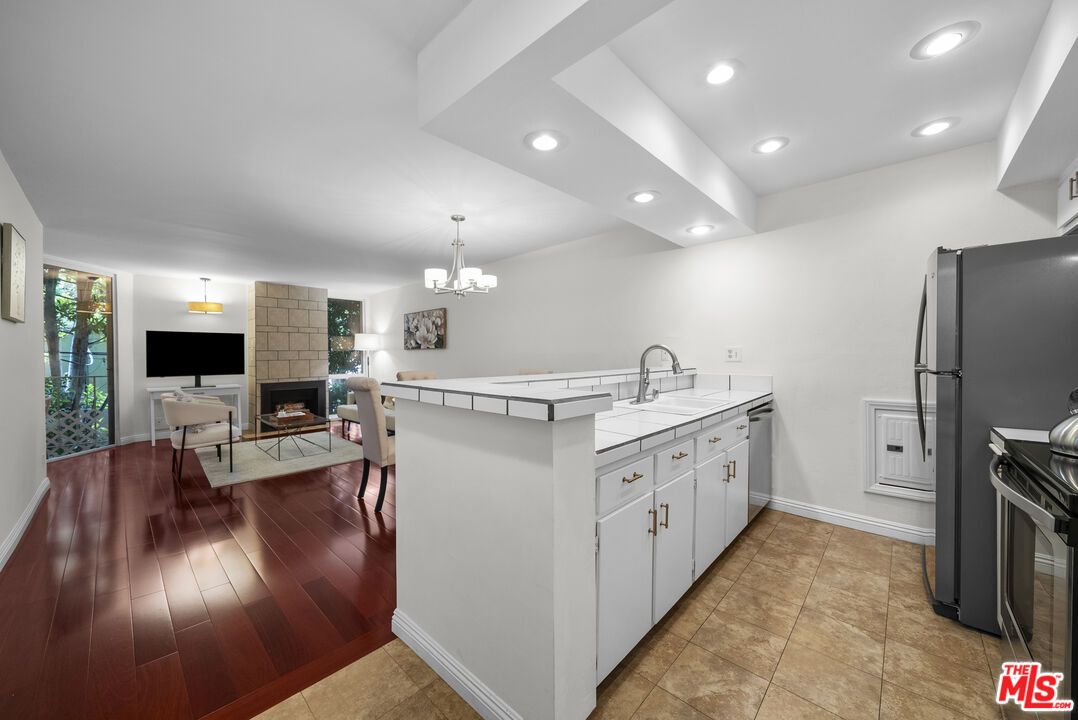 Chandelier, Dining room, Fireplace, Interior, Kitchen, Living room, Pendant Lights, Recessed Lighting, Tile Countertops, Wood Texture Flooring