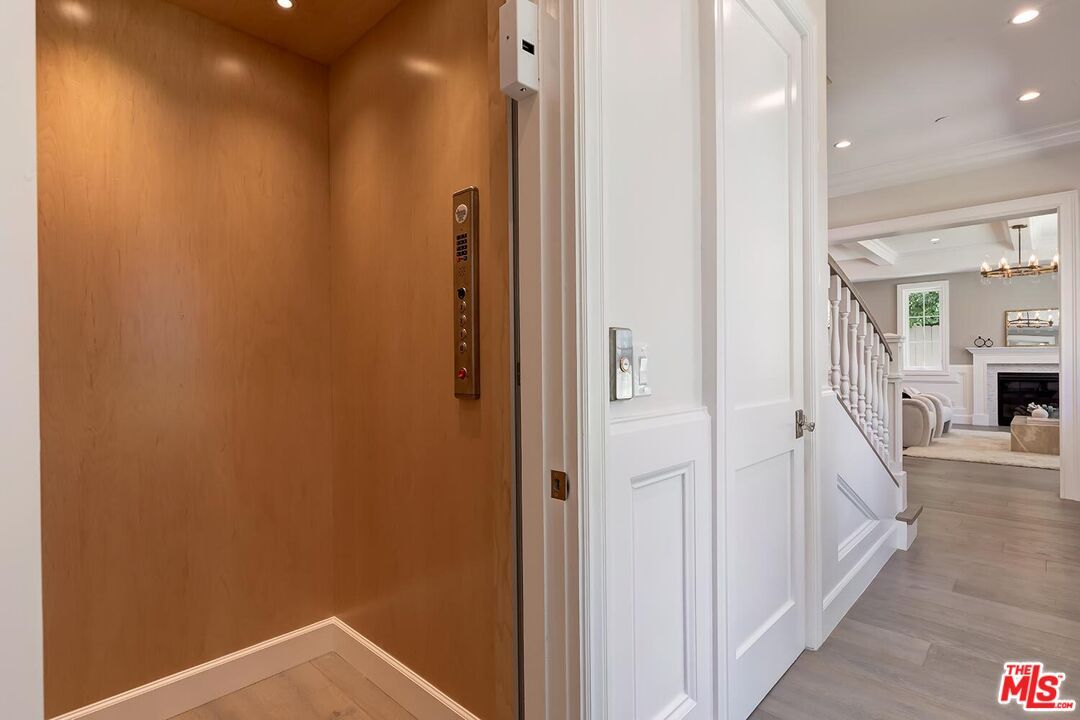 Chandelier, Elevator, Fireplace, Interior, Recessed Lighting, Wood Texture Flooring, Wooden Walls