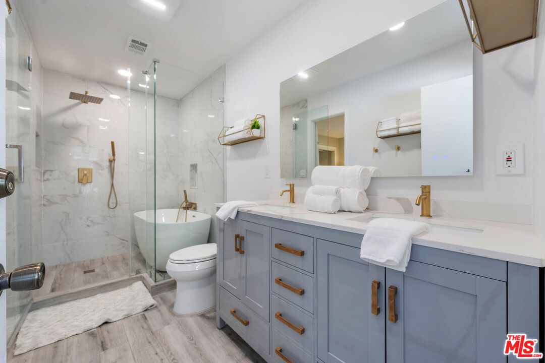 Bathroom, Dual Sink Vanities, Glass Shower, Interior, Marble Walls, Recessed Lighting, Wood Texture Flooring