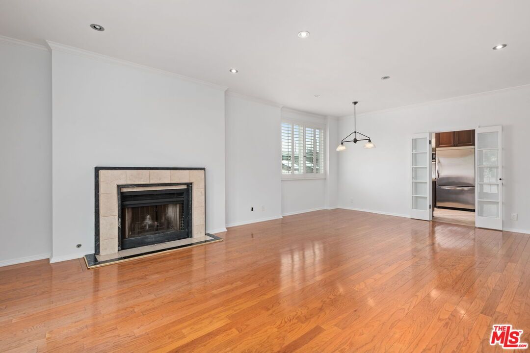 Empty room, Fireplace, Interior, Kitchen, Pendant Lights, Recessed Lighting, Stainless Steel Appliances, Wood Texture Flooring