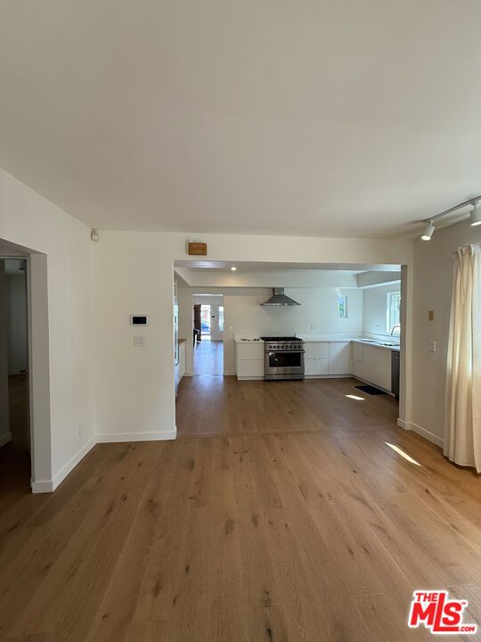 Empty room, Interior, Kitchen, Recessed Lighting, Stainless Steel Appliances, Wood Texture Flooring