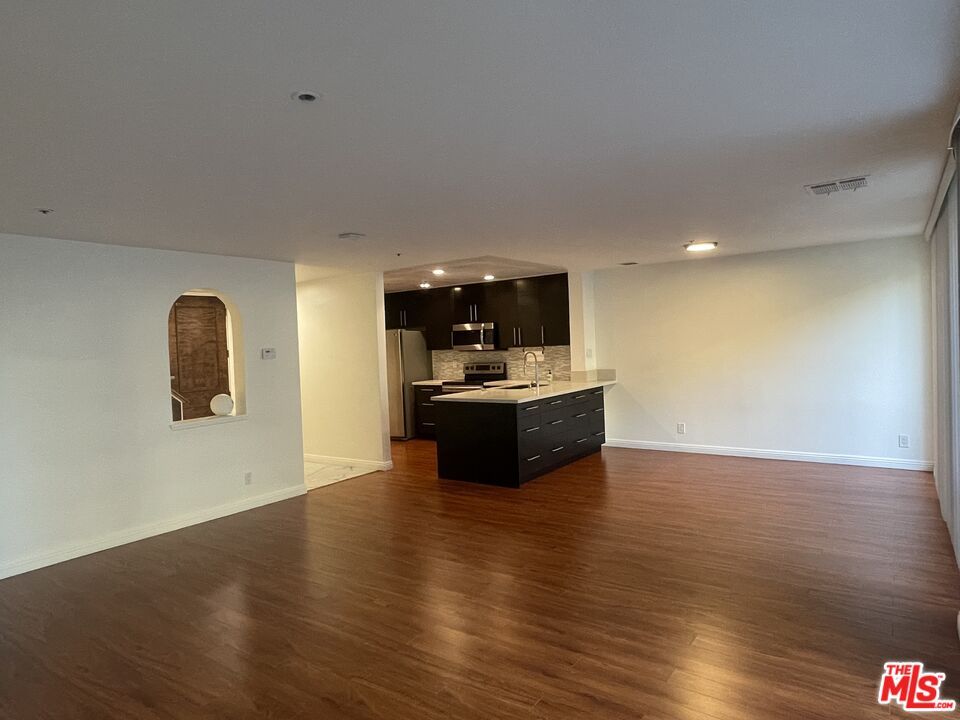 Empty room, Interior, Kitchen, Recessed Lighting, Stainless Steel Appliances, Wood Texture Flooring