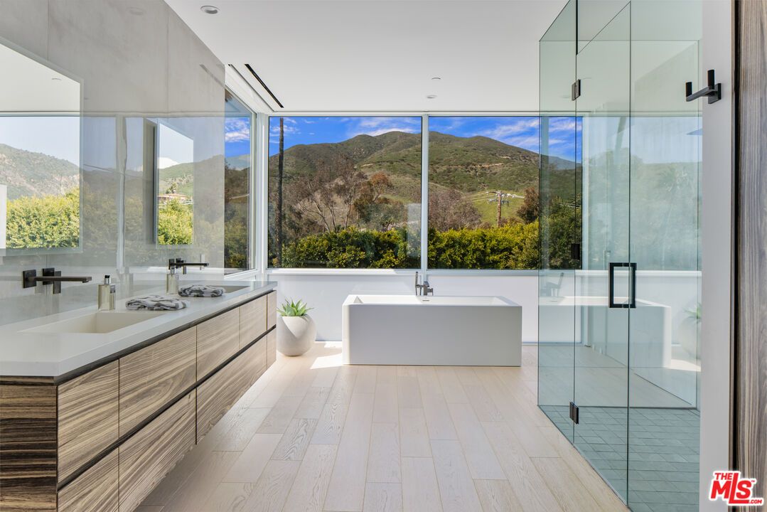 Bathroom, Dual Sink Vanities, Free Standing Baths, Glass Shower, Interior, Marble Walls, Recessed Lighting, Wood Texture Flooring