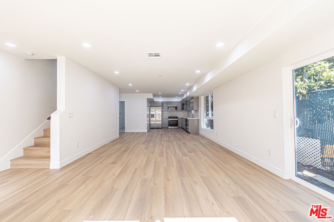 Empty room, Interior, Kitchen, Recessed Lighting, Stainless Steel Appliances, Wood Texture Flooring