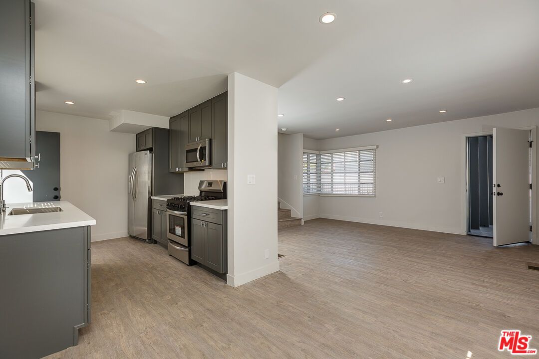Empty room, Interior, Kitchen, Recessed Lighting, Stainless Steel Appliances, Wood Texture Flooring
