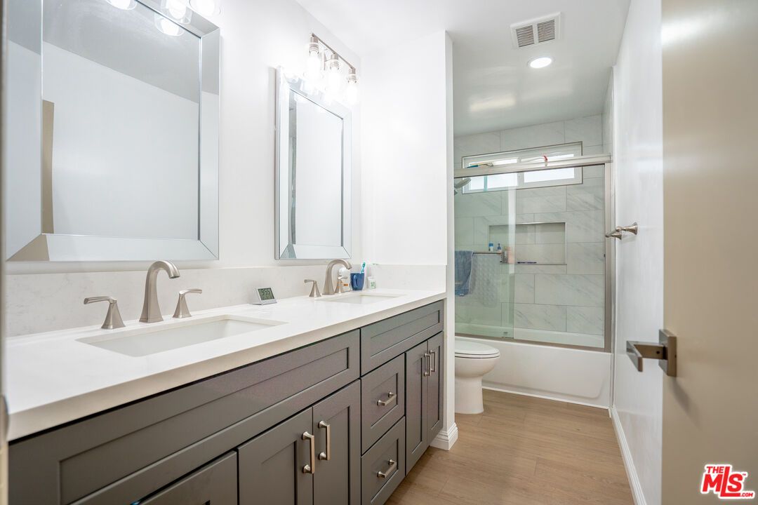 Bathroom, Dual Sink Vanities, Glass Shower, Interior, Marble Walls, Recessed Lighting, Wood Texture Flooring