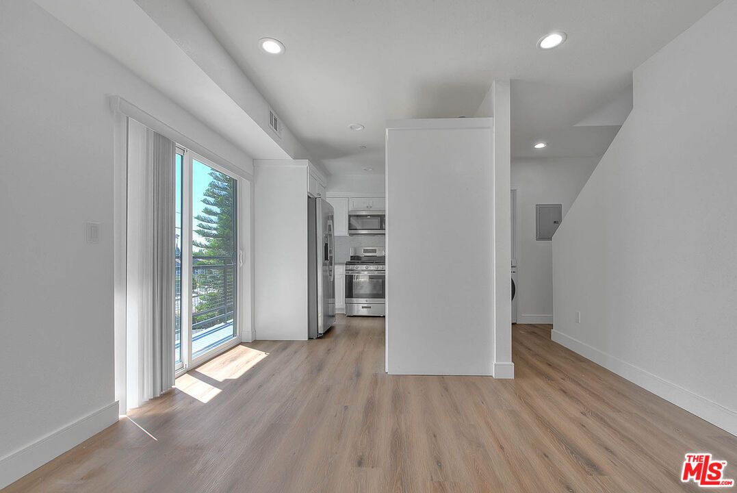 Empty room, Interior, Kitchen, Recessed Lighting, Stainless Steel Appliances, Wood Texture Flooring