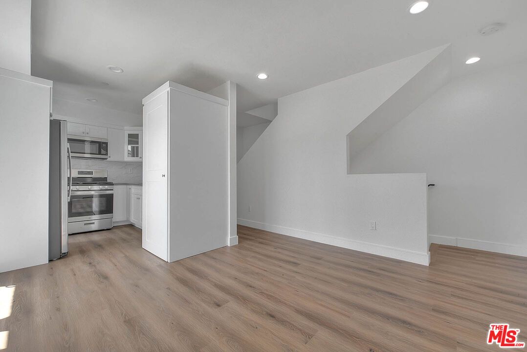 Empty room, Interior, Kitchen, Recessed Lighting, Stainless Steel Appliances, Wood Texture Flooring