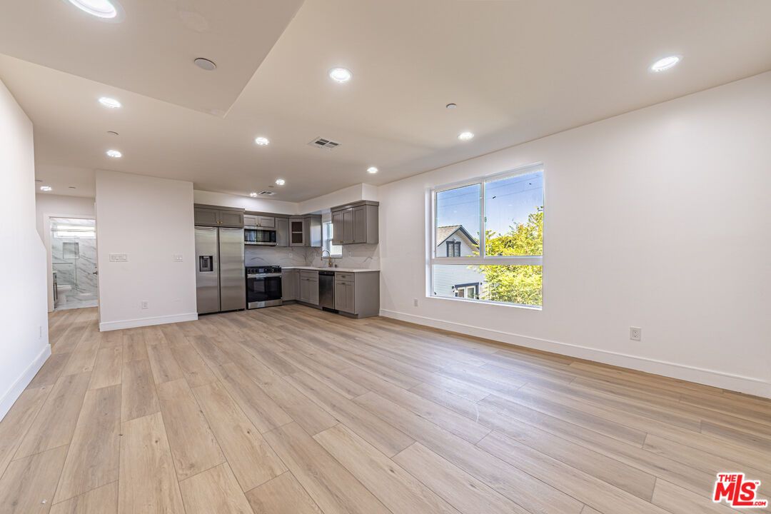 Empty room, Interior, Kitchen, Recessed Lighting, Stainless Steel Appliances, Wood Texture Flooring
