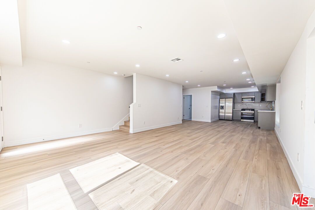 Empty room, Interior, Kitchen, Recessed Lighting, Stainless Steel Appliances, Wood Texture Flooring