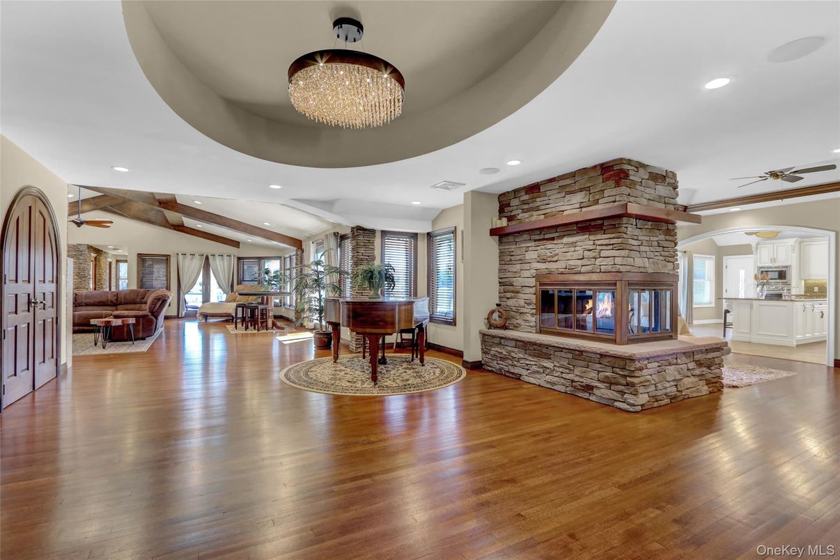 Chandelier, Fireplace, Interior, Living room, Piano, Recessed Lighting, Wooden Beams, Wood Texture Flooring