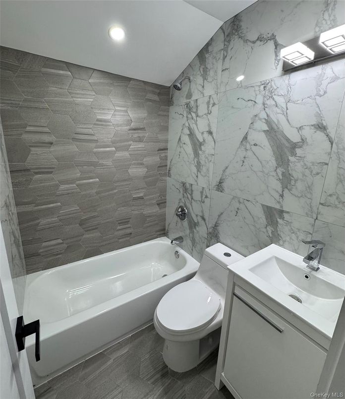 Bathroom, Dual Sink Vanities, Interior, Marble Walls, Recessed Lighting, Wood Texture Flooring