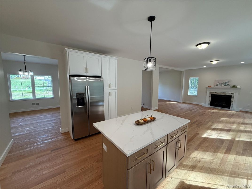 Empty room, Fireplace, Interior, Kitchen, Pendant Lights, Recessed Lighting, Stainless Steel Appliances, Wood Texture Flooring