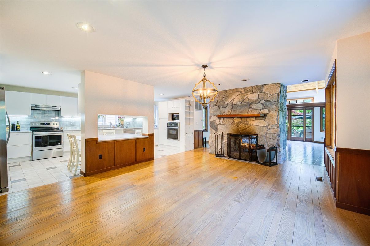 Chandelier, Fireplace, Interior, Kitchen, Pendant Lights, Recessed Lighting, Stainless Steel Appliances, Stone Walls, Wood Texture Flooring