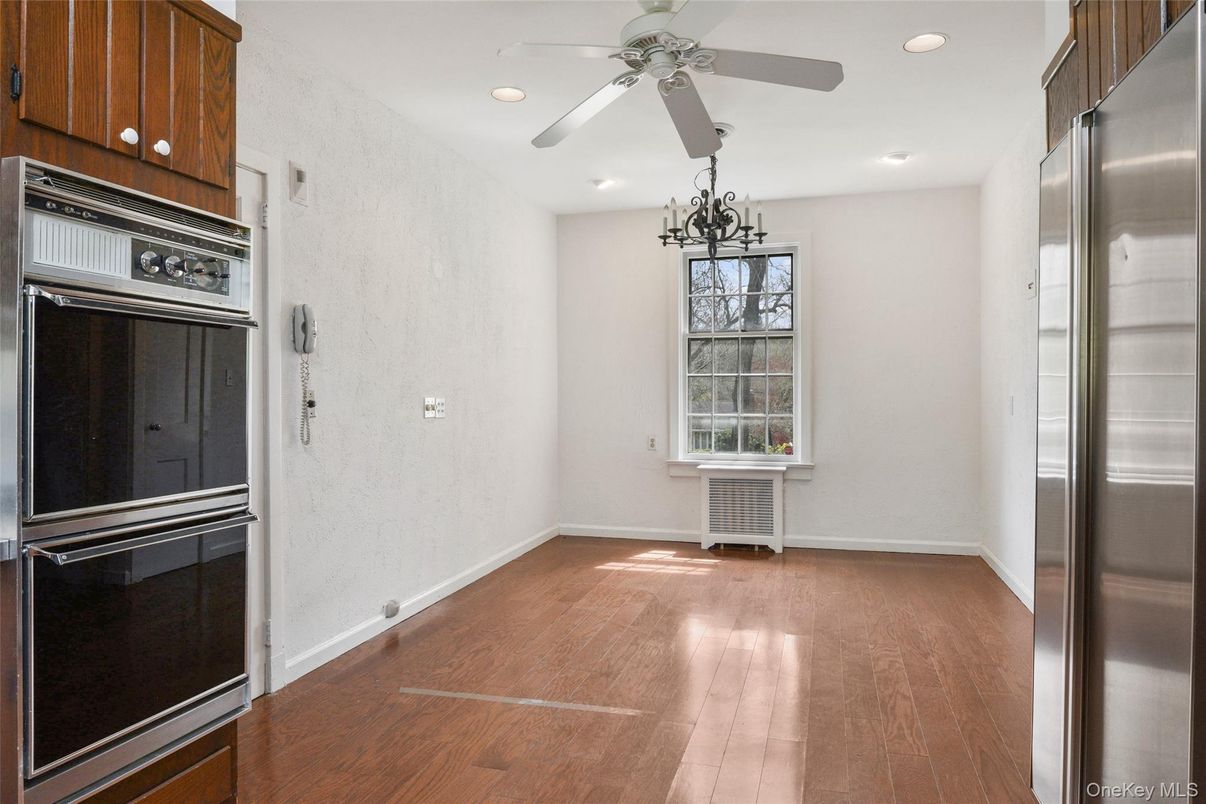 Empty room, Interior, Kitchen, Recessed Lighting, Stainless Steel Appliances, Wood Texture Flooring